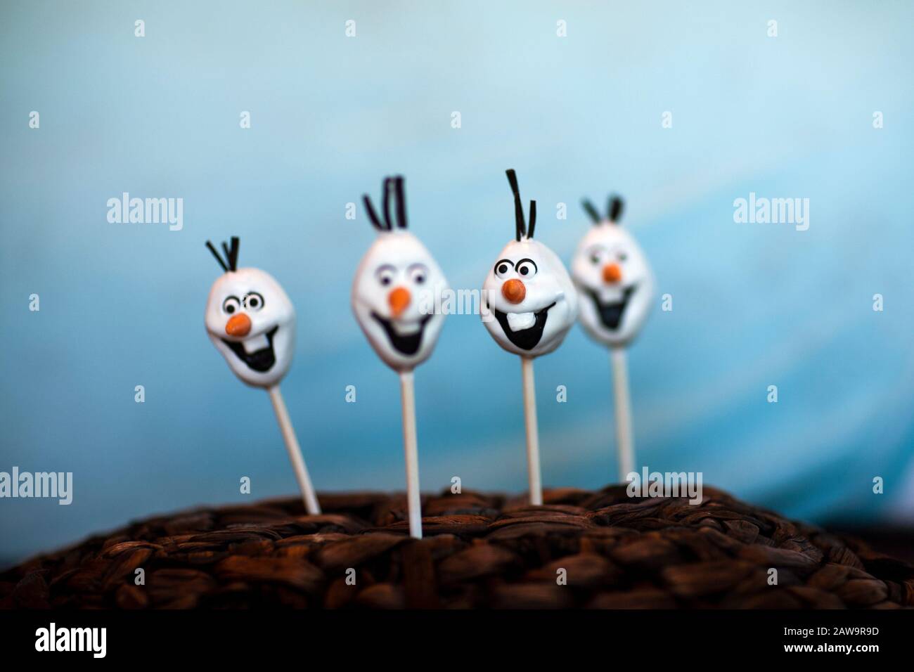 La torta di pupazzo di neve schiocca contro uno sfondo blu Foto Stock