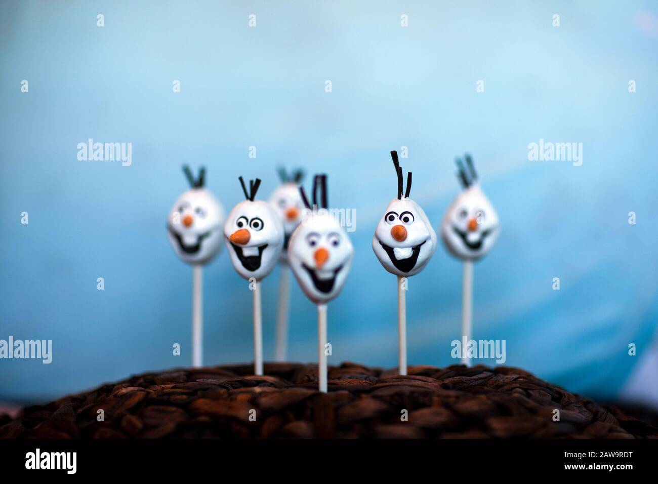 La torta di pupazzo di neve schiocca contro uno sfondo blu Foto Stock