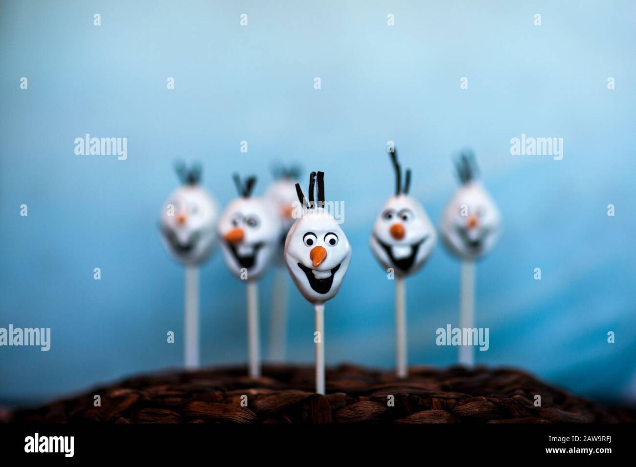 La torta di pupazzo di neve schiocca contro uno sfondo blu Foto Stock