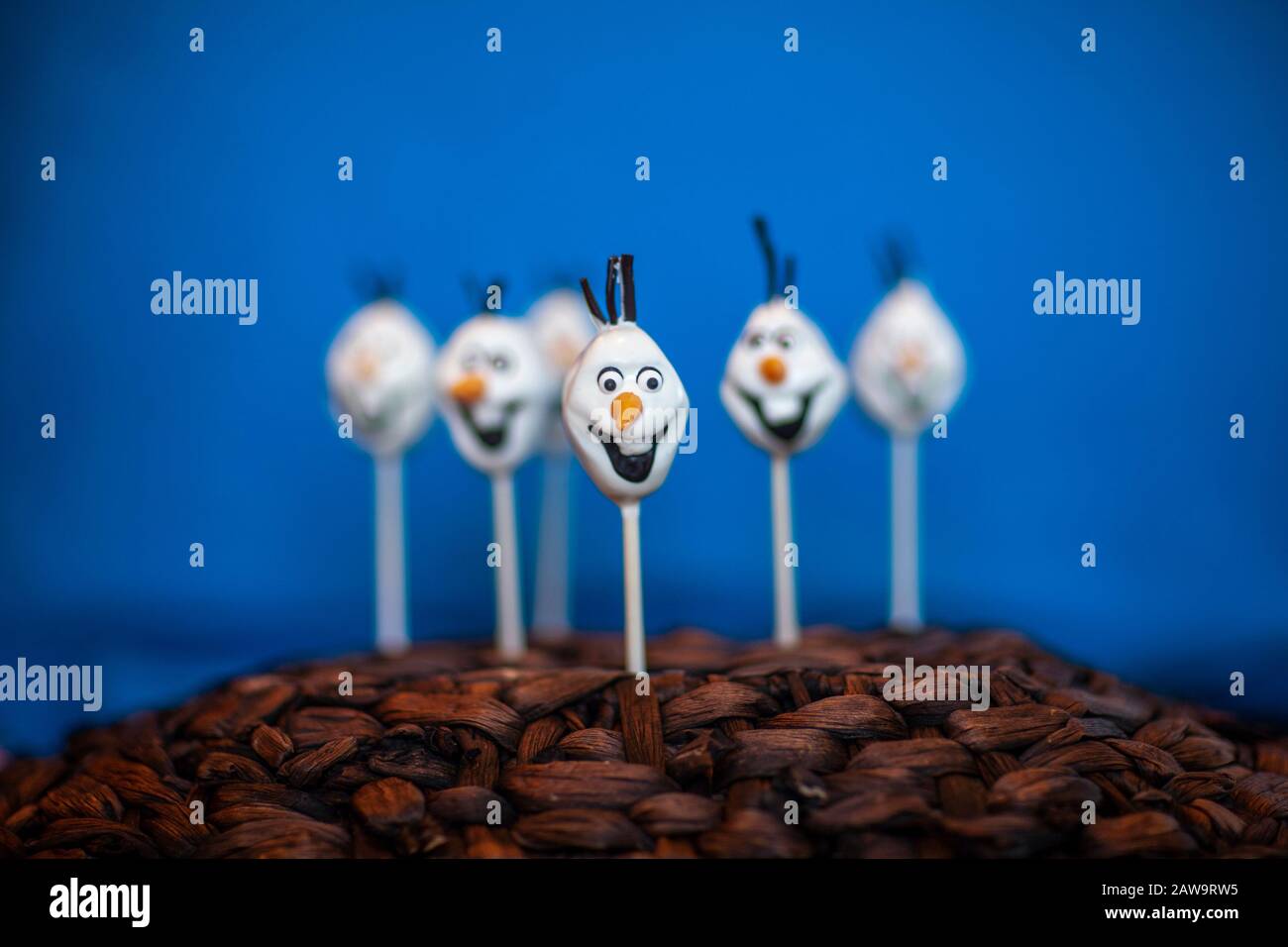 La torta di pupazzo di neve schiocca contro uno sfondo blu Foto Stock