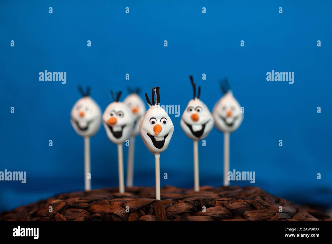 La torta di pupazzo di neve schiocca contro uno sfondo blu Foto Stock