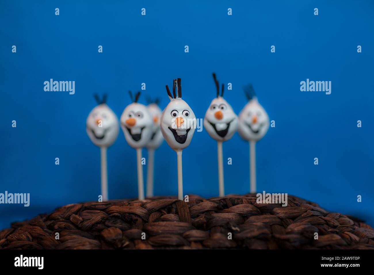 La torta di pupazzo di neve schiocca contro uno sfondo blu Foto Stock