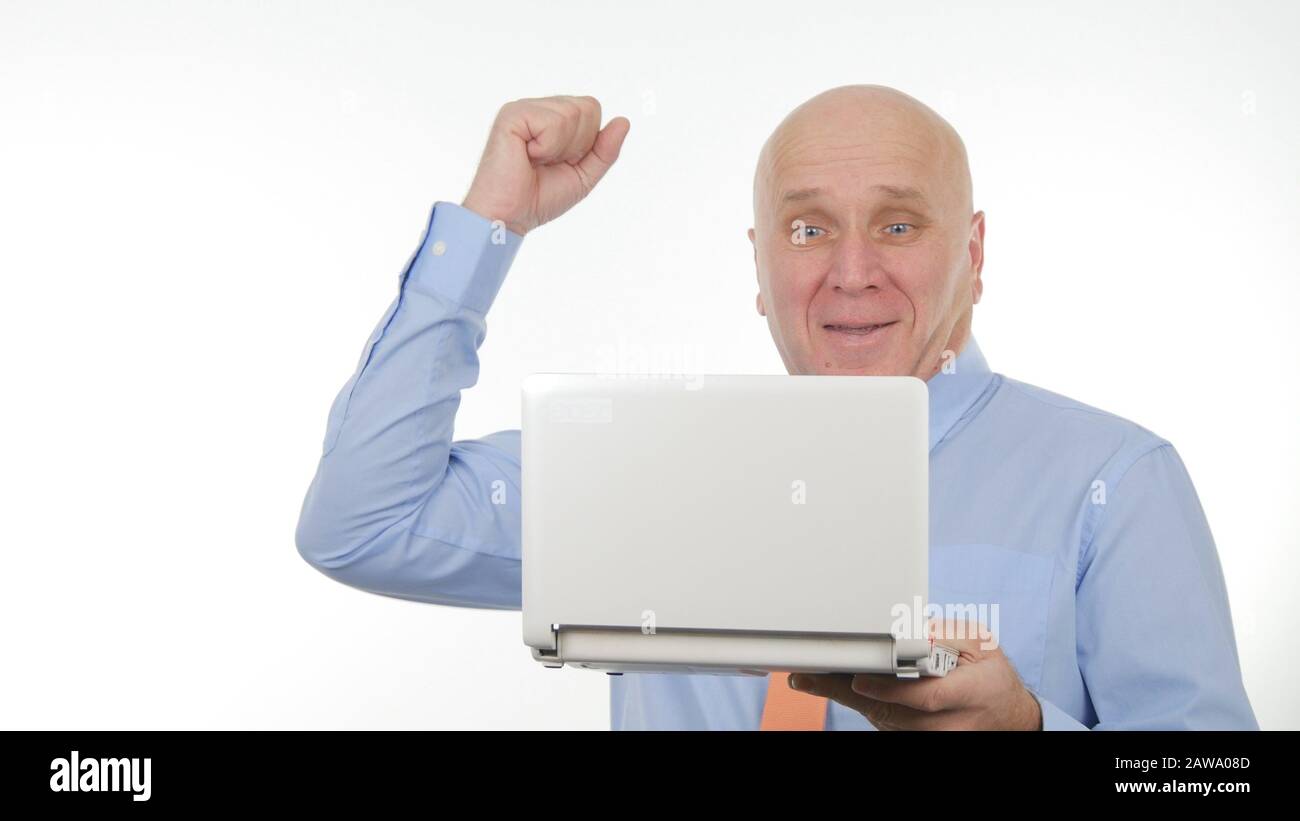 Felice Uomo D'Affari Smile Leggere Buone Notizie Finanziarie Sul Laptop Gesturing Sorpreso, Concetto Di Gesti Del Vincitore Foto Stock