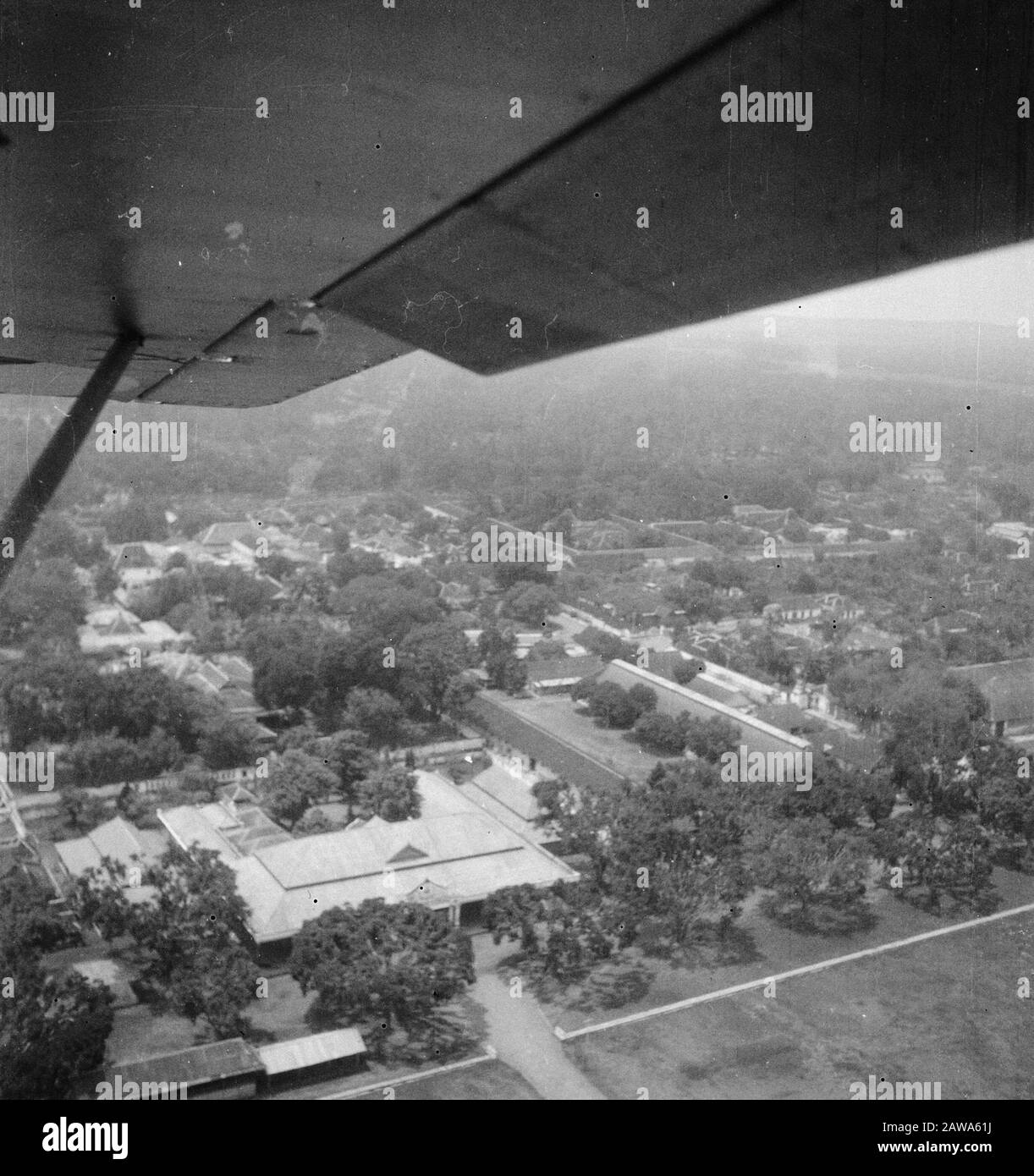 Foto aeree Kraton Yogya (ripresa da Austre) Vista aerea. Vista aerea del Kraton a Djocja. Il Kraton è il luogo in cui vive il sultano. È una città in sé, con templi, negozi, luoghi di lavoro e quartieri. La struttura è circondata da alte pareti, spesso decorate in modo elaborato. Data: 21 Marzo 1949 Luogo: Indonesia, Indie Orientali Olandesi, Yogyakarta Foto Stock