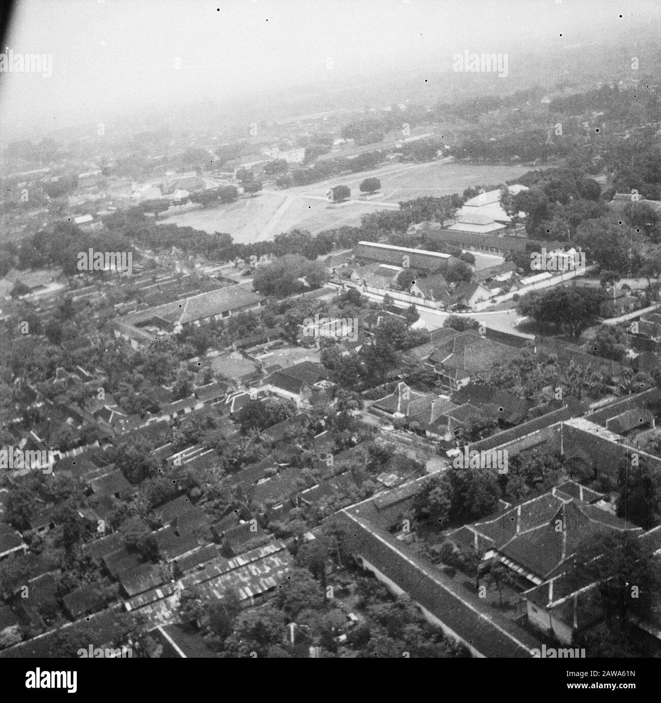 Foto aeree Kraton Yogya (ripresa da Austre) Vista aerea. Vista aerea del Kraton a Djocja. Il Kraton è il luogo in cui vive il sultano. È una città in sé, con templi, negozi, luoghi di lavoro e quartieri. La struttura è circondata da alte pareti, spesso decorate in modo elaborato. Data: 21 Marzo 1949 Luogo: Indonesia, Indie Orientali Olandesi, Yogyakarta Foto Stock