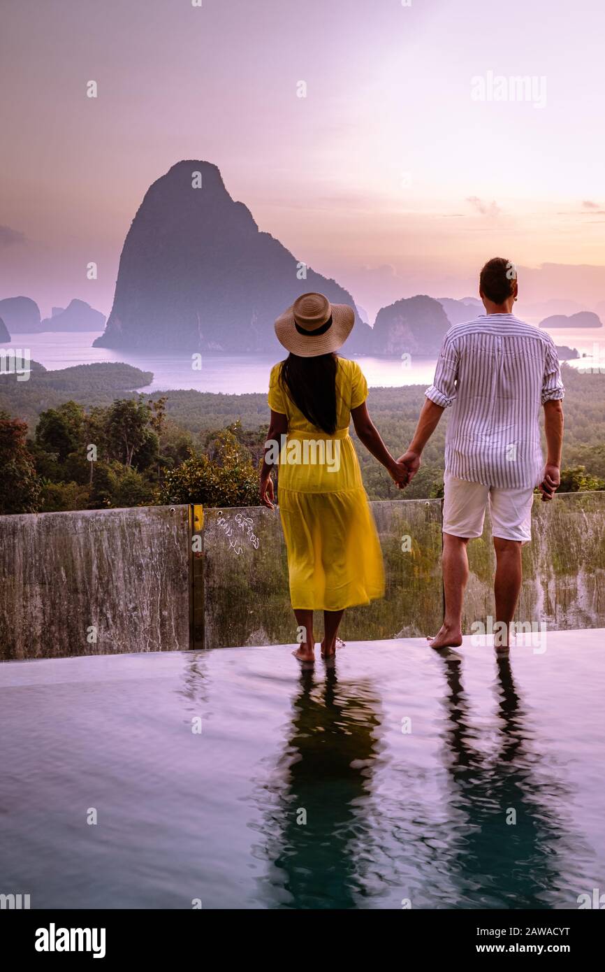 Phangnga Bay Thailandia, coppia sul bordo di una piscina guardando sunrise Thailandia Infinity piscina Foto Stock