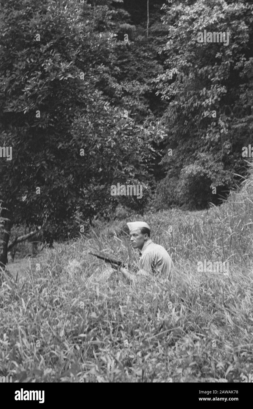 Descrizione Medan: Soldato con fucile accovacciato nel raccolto Data: 1947 Località: Indonesia, Indie Orientali Olandesi, Sumatra Foto Stock