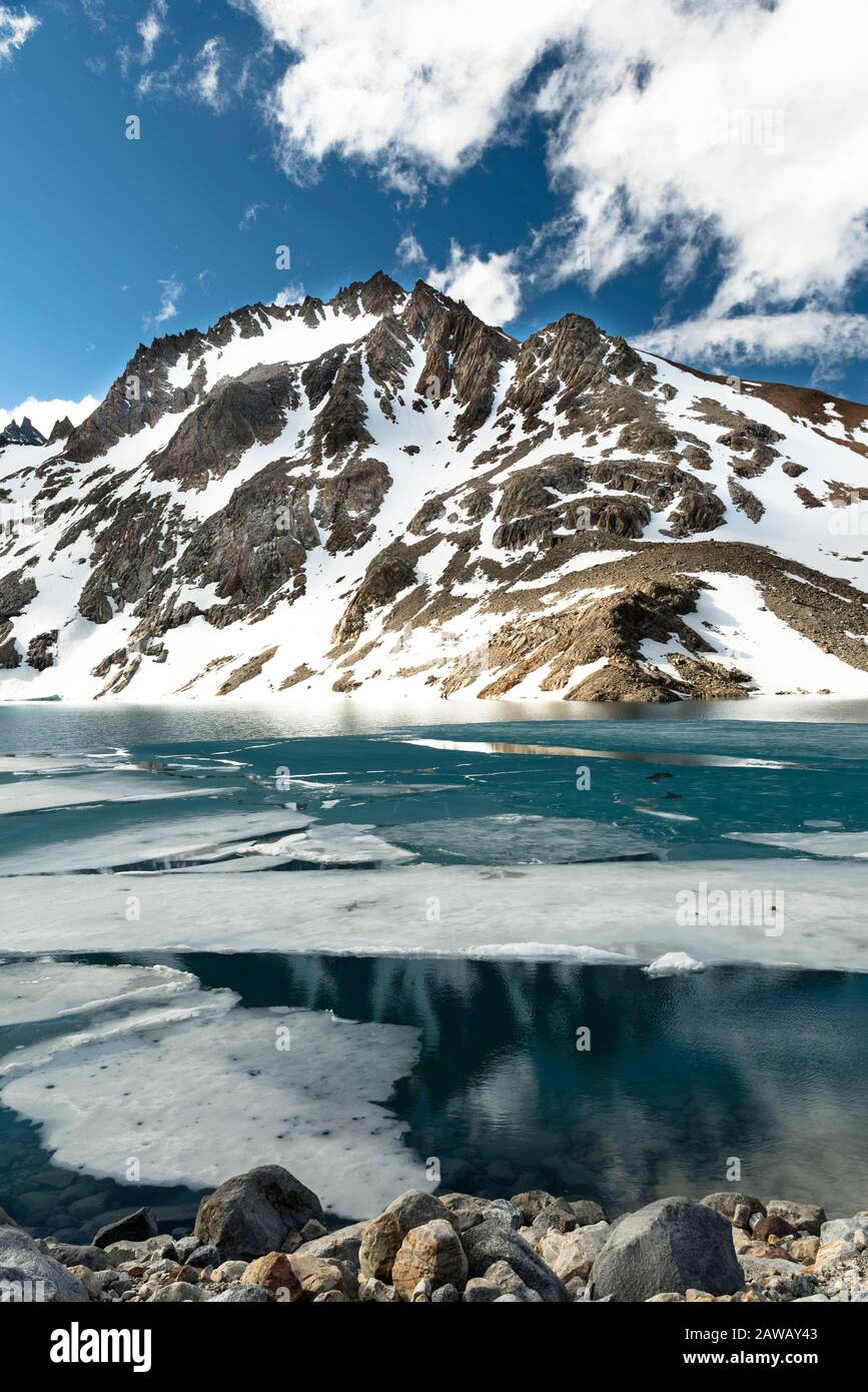 Splendida immagine di un lago Blue Water con neve e montagne sullo sfondo Foto Stock