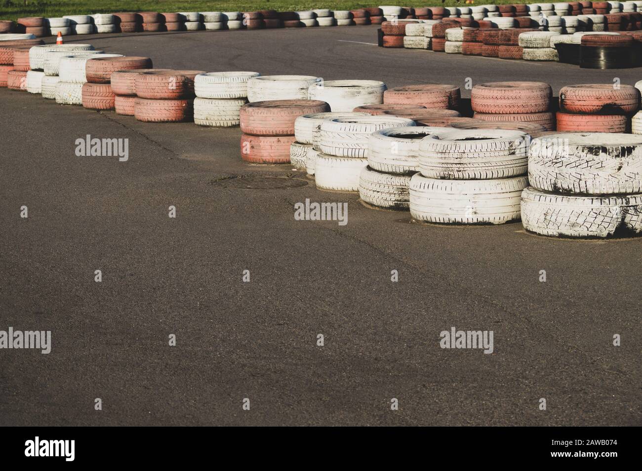 Barriera di sicurezza pista da gara. Pista asfalto con gomme rosse e bianche. Cataste colorate. Pista Karting Foto Stock