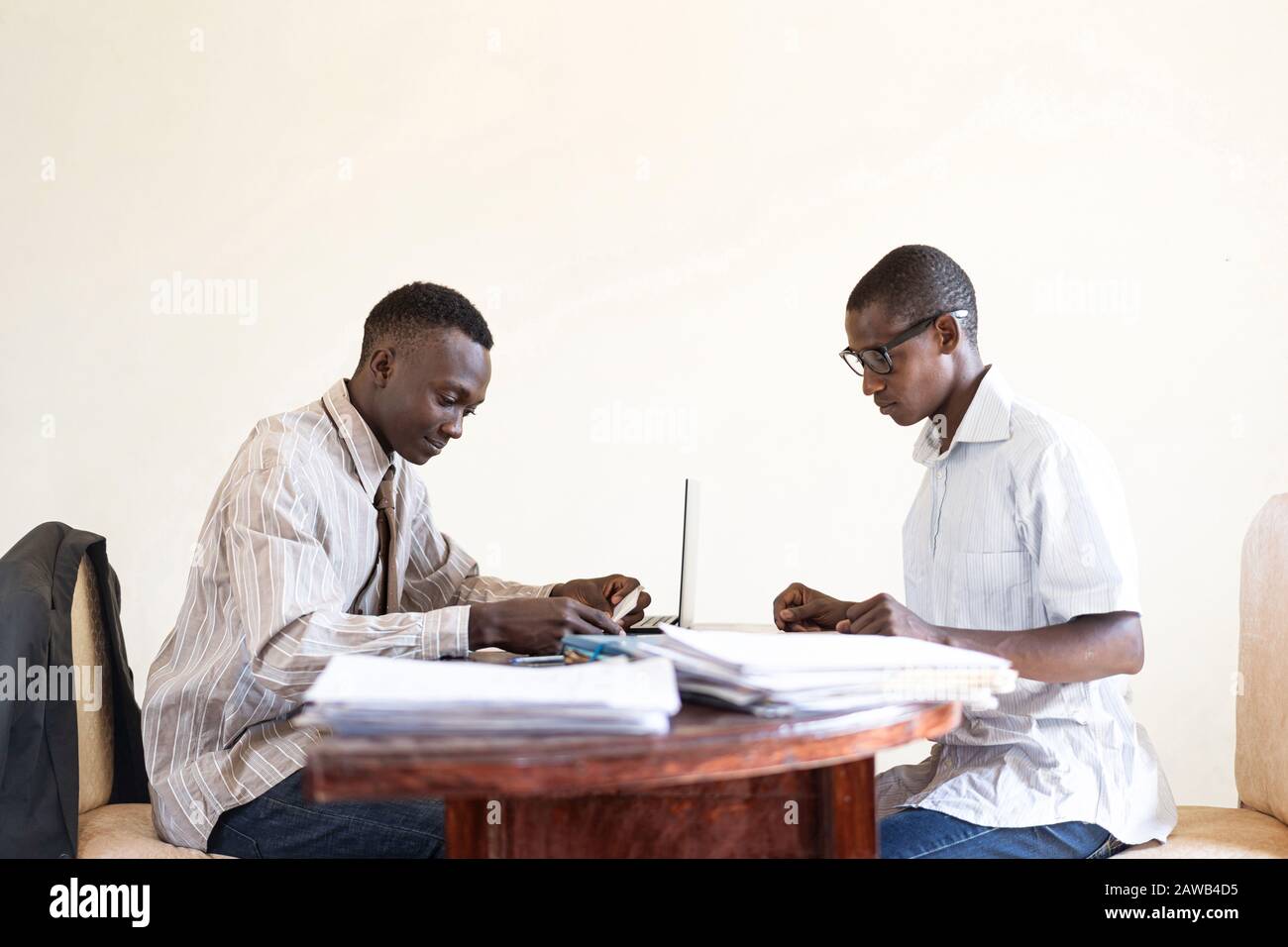 Coppia di uomini neri africani Che Lavorano insieme in un tipico ufficio africano Foto Stock