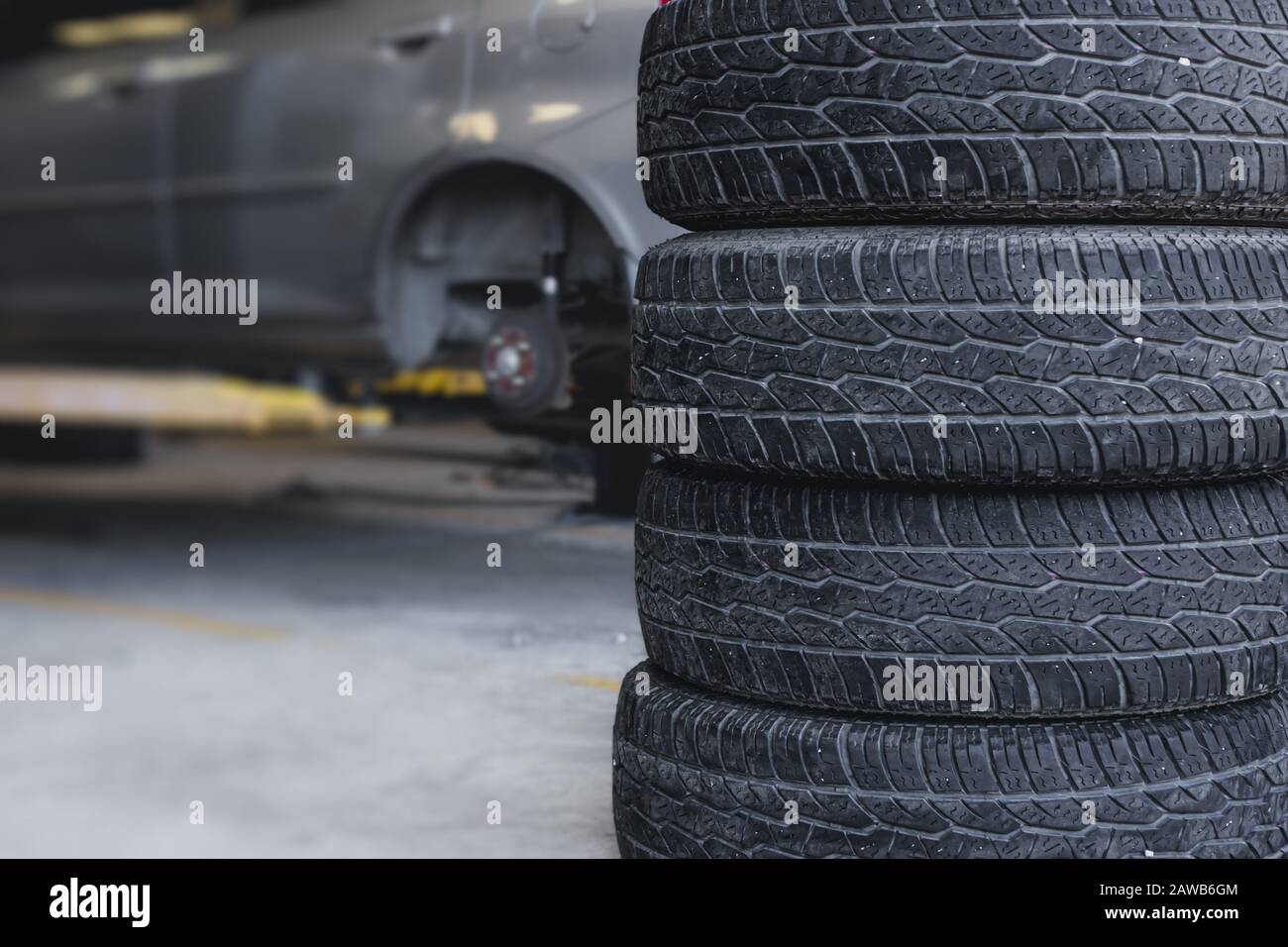 Sostituzione pneumatici auto in garage, vecchia ruota di servizio per lo sfondo. Foto Stock