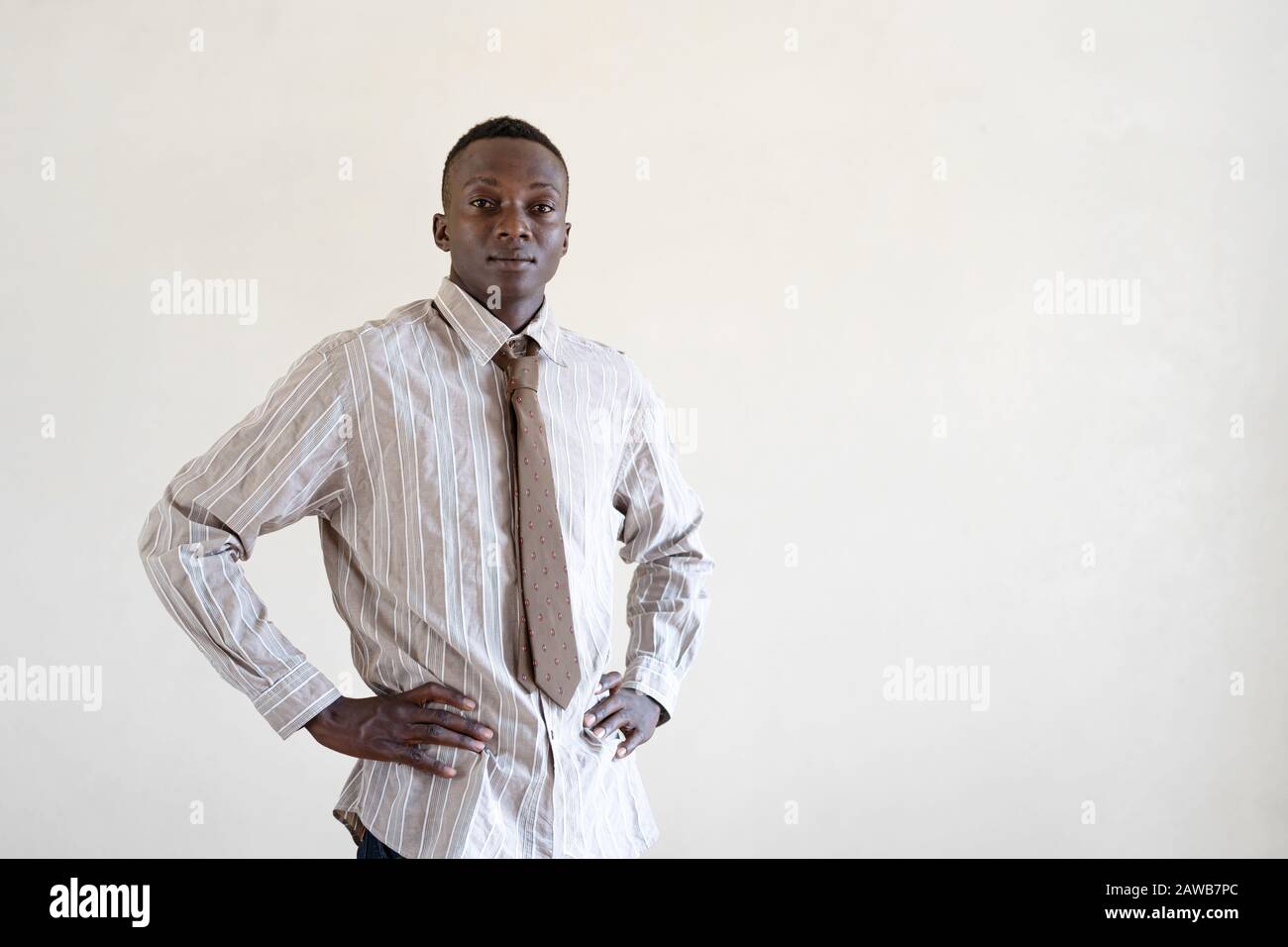 Bel ragazzo di etnia africana nera con camicia in posa per la fotocamera Foto Stock