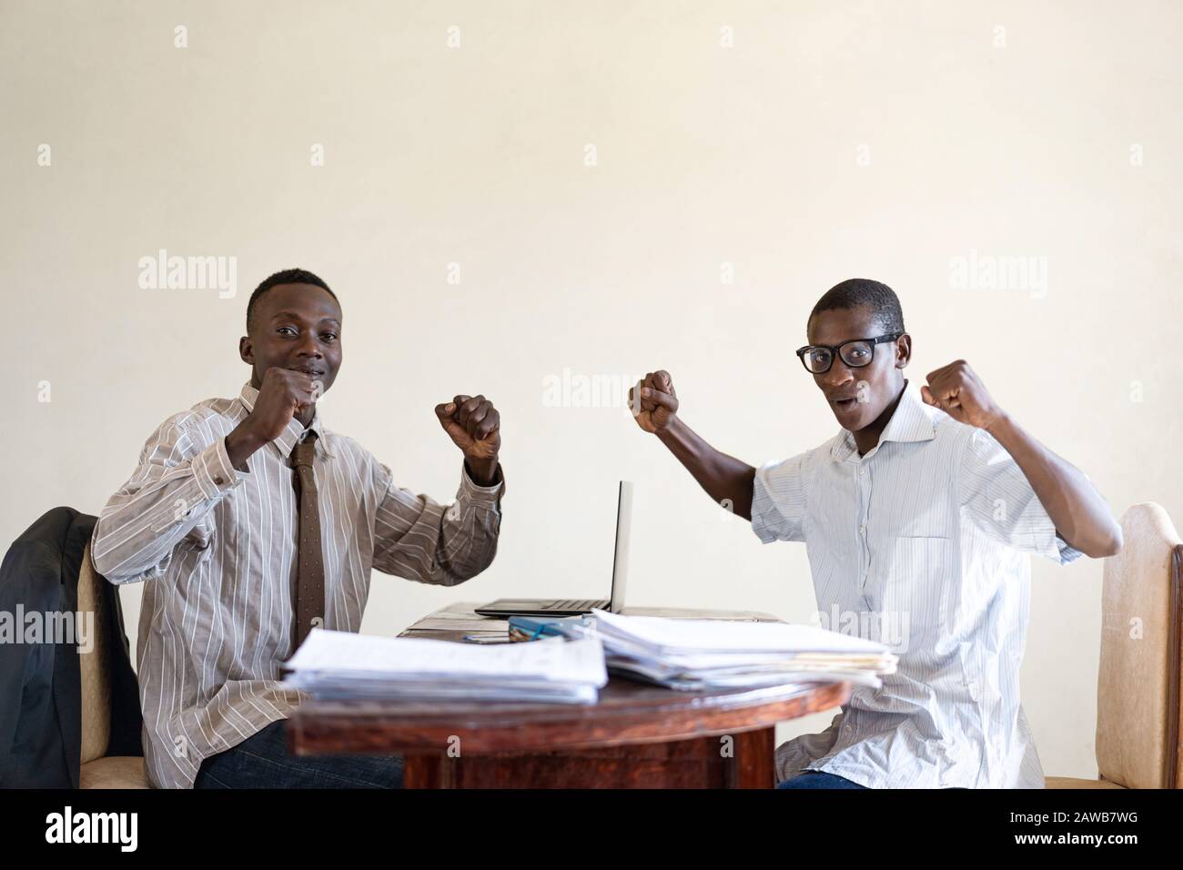 Gli Uomini D'Affari africani neri eccitati Lavorano insieme e sorridono e ridono felicemente nell'ufficio bianco Foto Stock