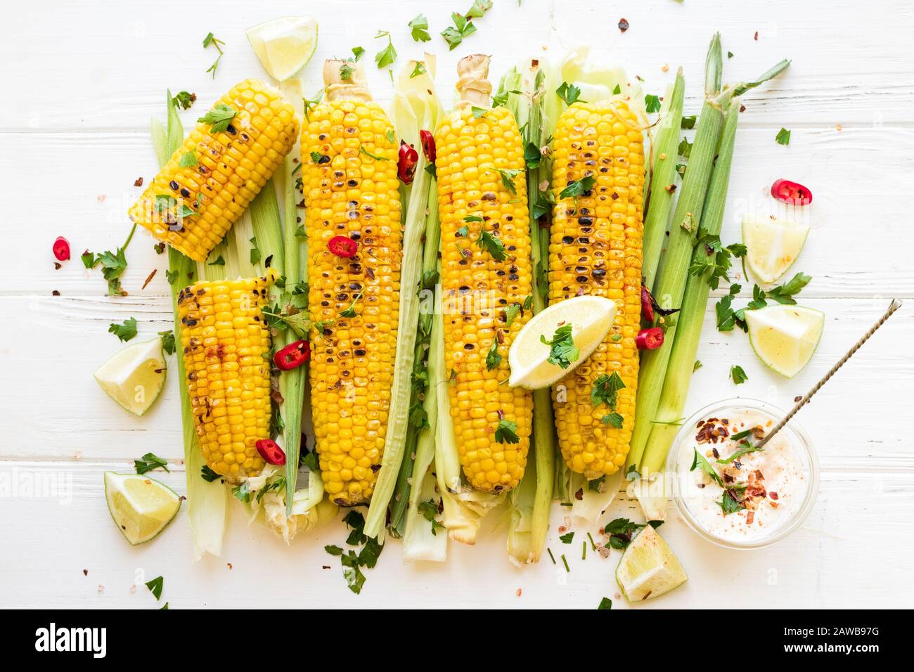 Pannocchie di mais alla griglia in stile messicano con lime, coriandolo,  peperoncino e salsa bianca su sfondo nero. Vista dall'alto Foto stock -  Alamy