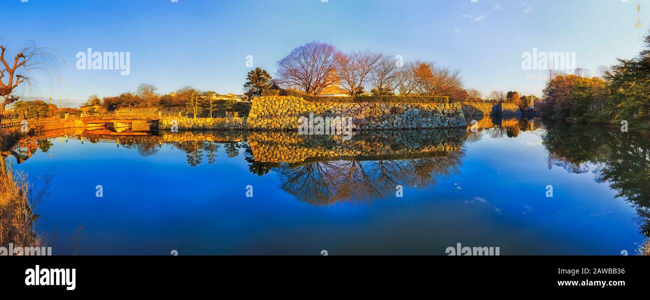 Panorama dello storico parco pubblico nella città di Himeji del Giappone intorno al vecchio castello bianco con forti mura di pietra. Foto Stock