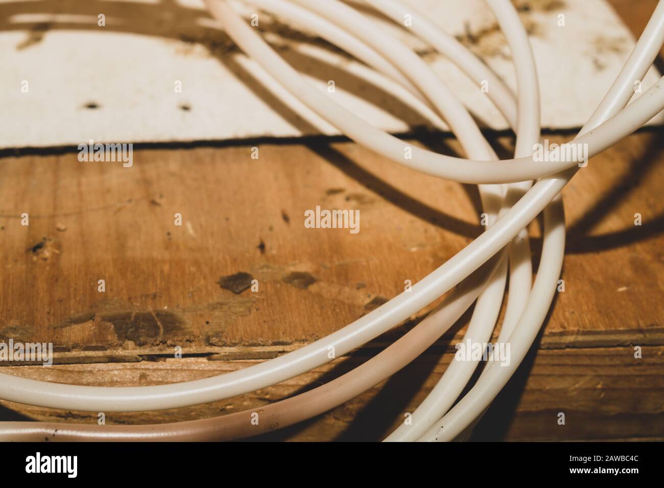 Il cavo bianco si trova sul tavolo in legno. Il cavo di collegamento si avvicina Foto Stock