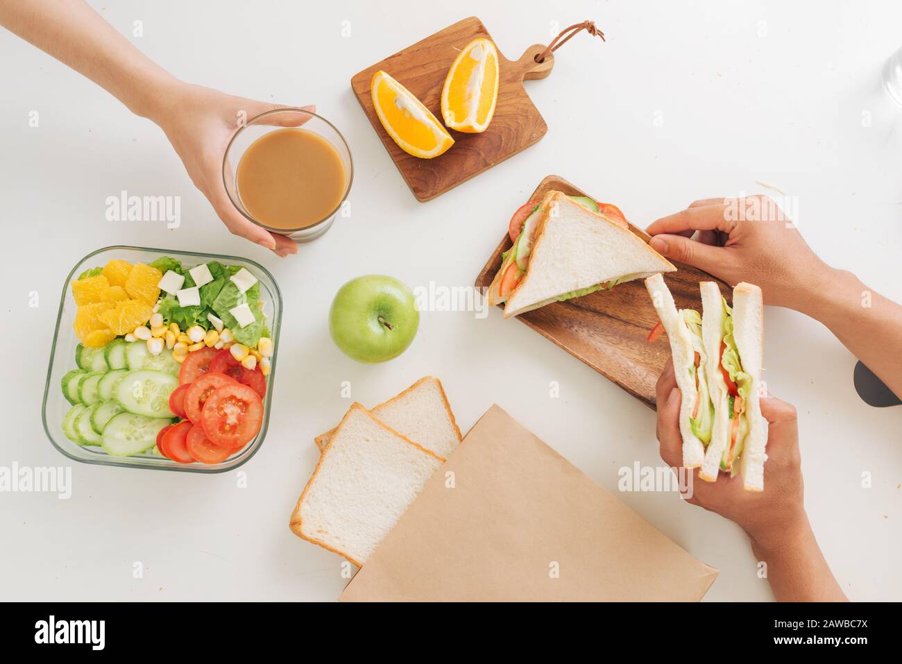 Giovane coppia che ha colazione con panini al tavolo in cucina, closeup Foto Stock