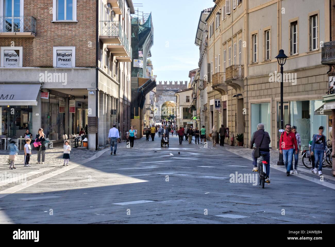 Rimini, Italia - 20 ottobre 2019: Arco di Augusto visto da Piazza tre Martiri (Piazza Tre Martiri) con qualche movimento sfocato pedoni e negozio Foto Stock