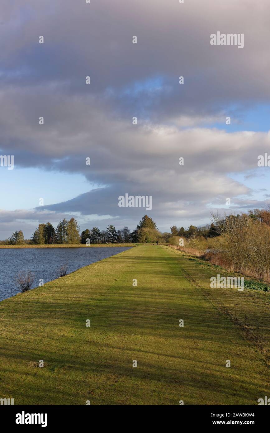 L'argine pianeggiante e erboso che divide i 2 Serbatoi del Monikie Country Park nella Campagna fuori Dundee. Foto Stock