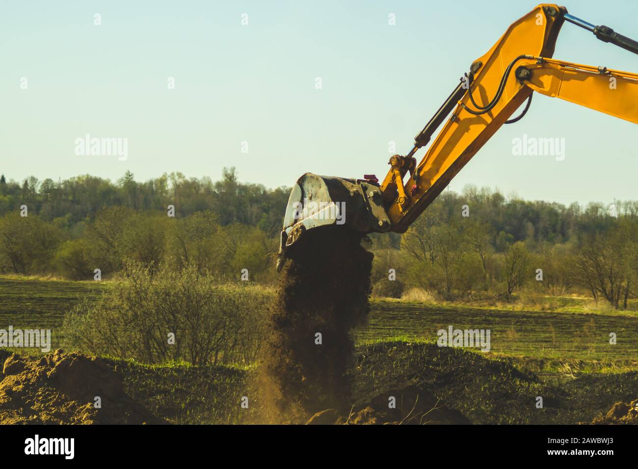 Escavatore scavare il terreno. Parte di attrezzatura di movimento terra di costruzione. Scavando e riempiendo il suolo con una benna di escavatore Foto Stock