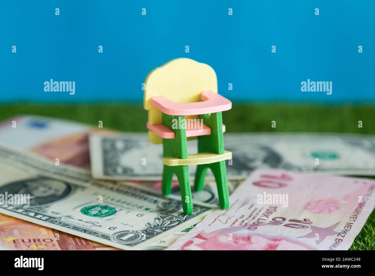 Fotografia concettuale, costo di mantenimento di un bambino, spese per la raccolta di cibo, abbigliamento e istruzione. Foto Stock