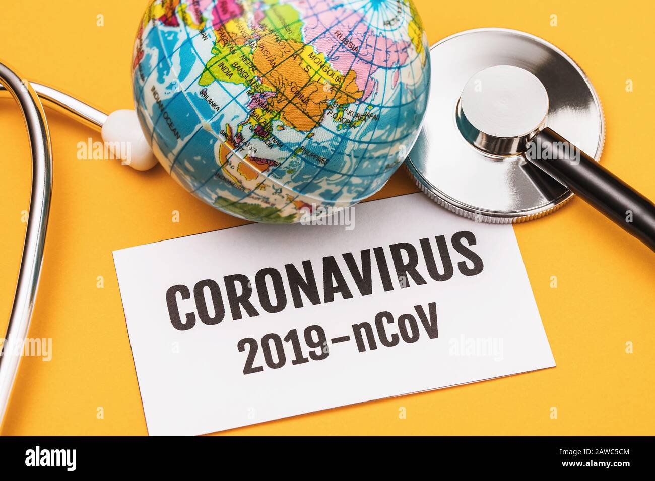 Uno stetoscopio, un globo giocattolo e un foglio di carta con l'iscrizione. Concetto sulla nuova minaccia Coronavirus 2019-nCoV in diversi paesi Foto Stock