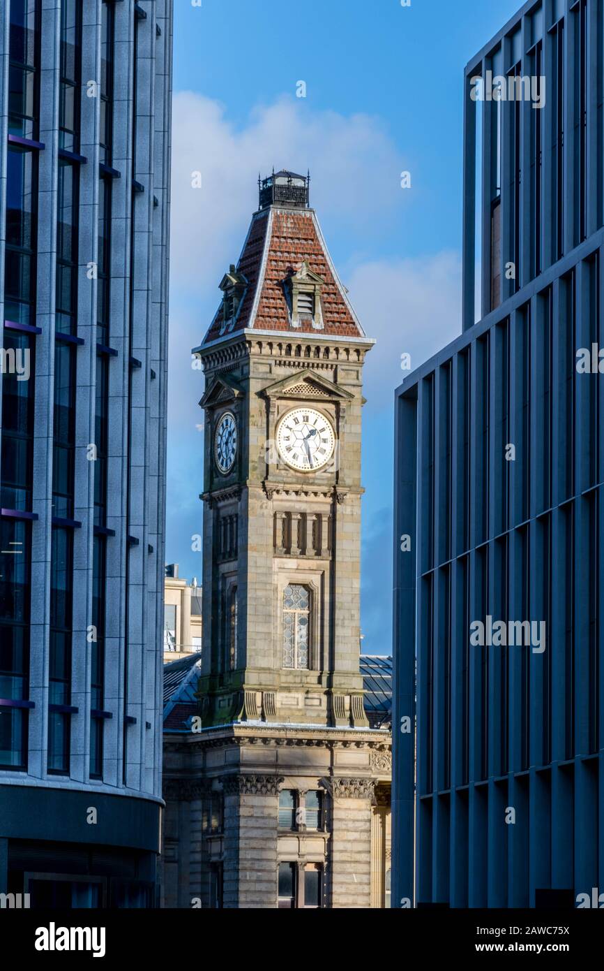 Vecchia torre dell'orologio tra nuovi edifici in vetro Foto Stock