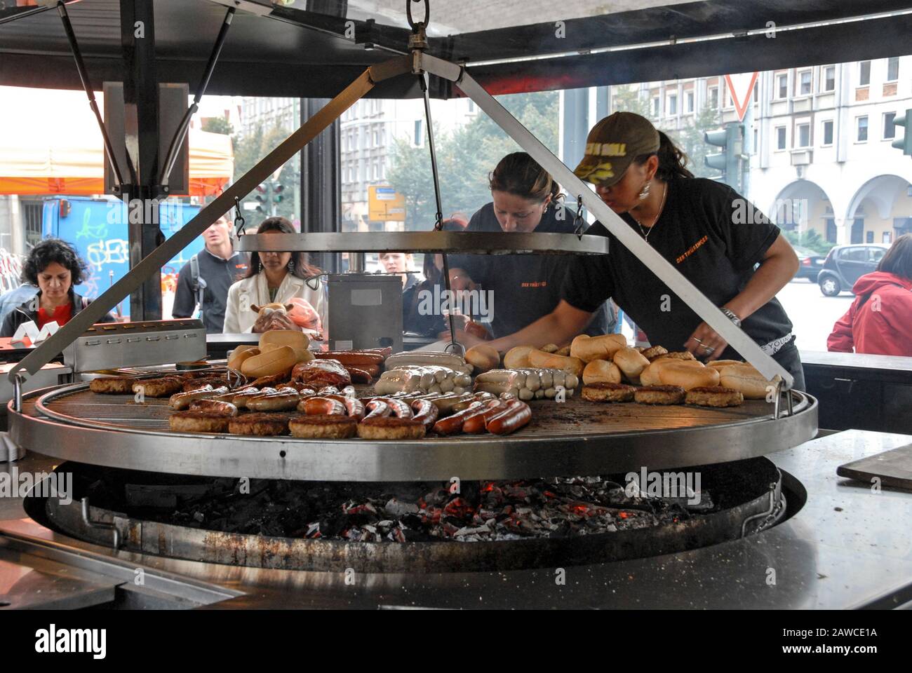 Due cuocini cucinano una massa di salsicce tedesche su una griglia  circolare aperta in una delle bancarelle originali di salsiccia della  Turingia ad Alexanderplatz in ce Foto stock - Alamy