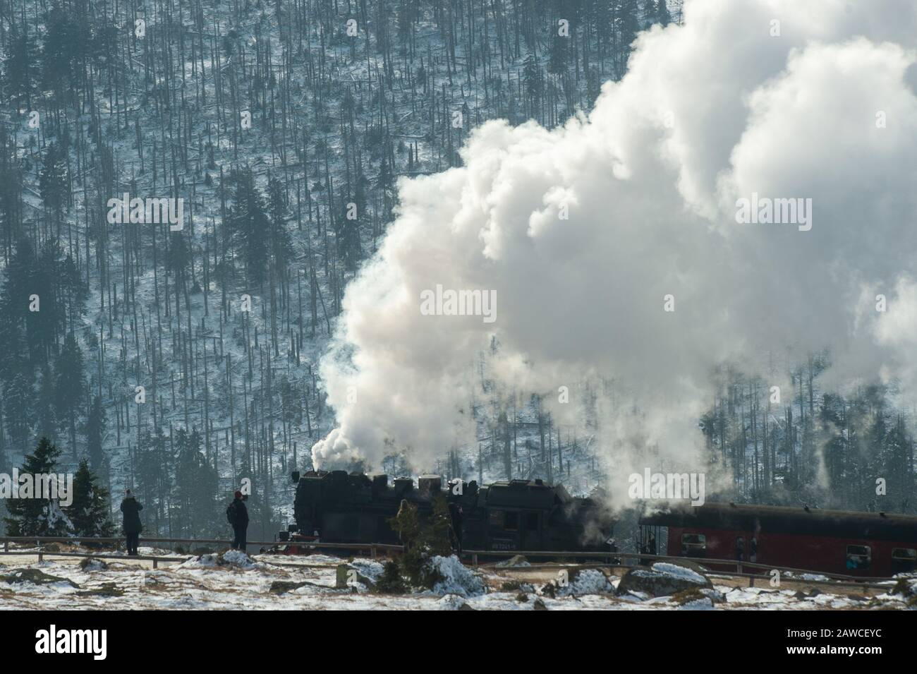 Wernigerode, Germania. 08th Feb, 2020. I turisti si trovano sulla cima di Brocken, mentre sullo sfondo un treno della Harzer Schmalspurbahnen (HSB) raggiunge la più alta quota della Harz. Il tempo nelle montagne di Harz dovrebbe cambiare radicalmente nei prossimi giorni. Nella notte di Lunedi una tempesta bassa raggiunge la regione. Poi il vento può raggiungere la forza degli uragani anche nelle pianure. Credito: Klaus-Dietmar Gabbert/Dpa-Zentralbild/Dpa/Alamy Live News Foto Stock