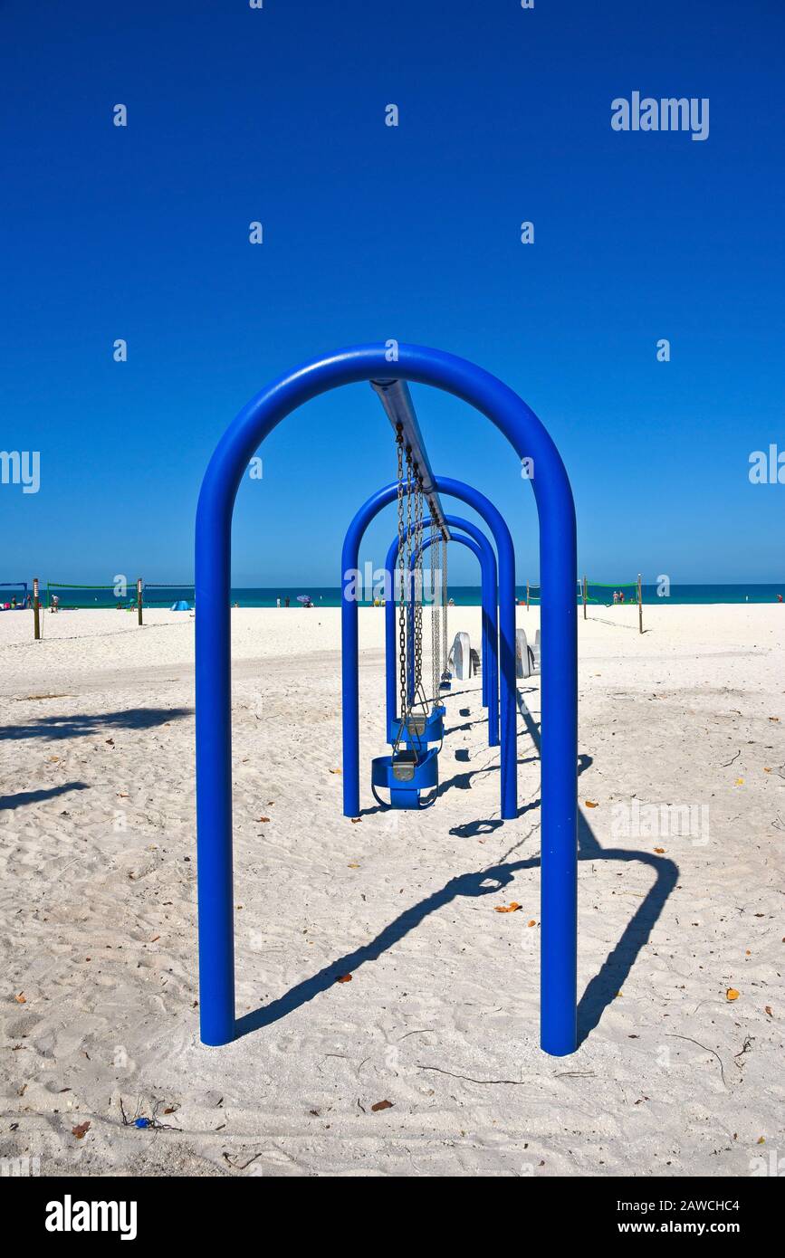 Un Grande swing di Metallo blu Posto su una spiaggia di sabbia Foto Stock
