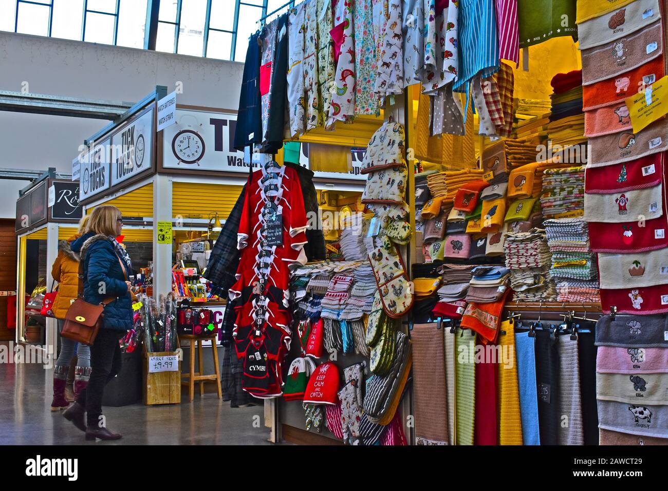 Mercato interno "nuovo" di Carmarthen. Gli acquirenti che esplorano bancarelle colorate. Articoli mulit-colorati per la vendita Foto Stock