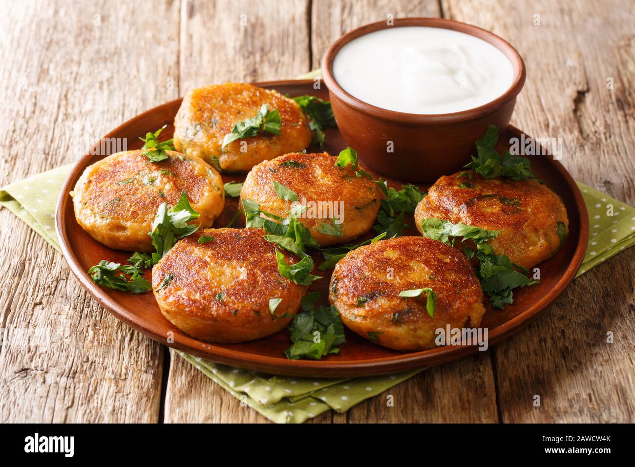 Street food dell'India. Patate Aloo Tikki servito con yogurt closeup in un piatto sul tavolo. Orizzontale Foto Stock