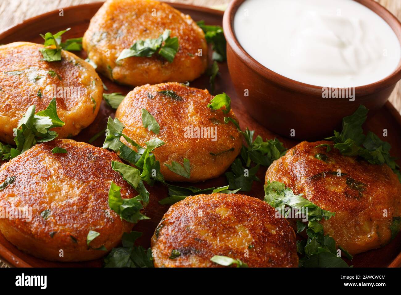 Gustoso Aloo Tikki è un popolare cibo di strada indiano che è fondamentalmente croccante e piccante patate patty con yogurt primo piano in un piatto sul tavolo Foto Stock