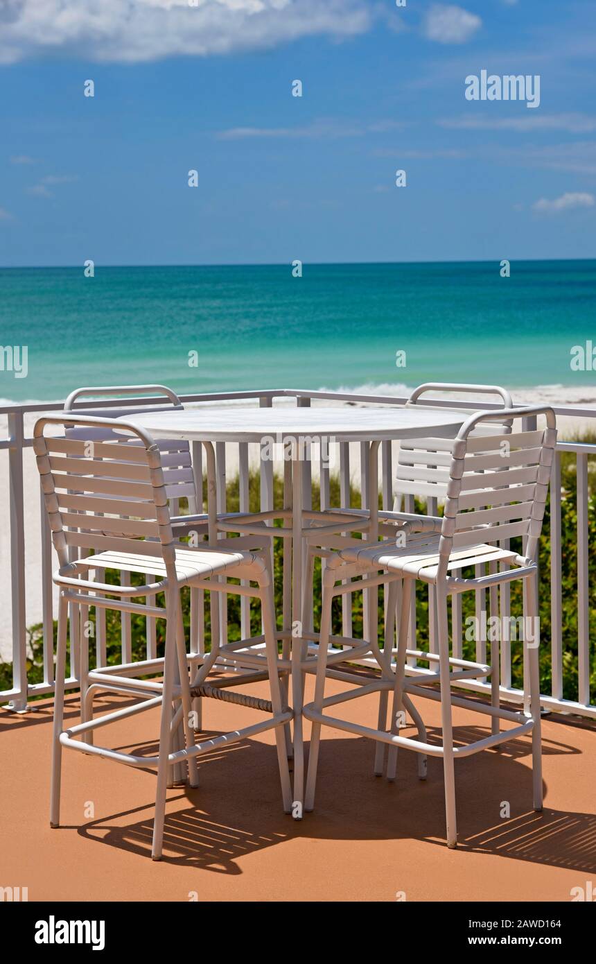 Tavolo e sedie all'aperto su un patio affacciato sulla spiaggia di sabbia bianca sul Golfo del Messico Foto Stock