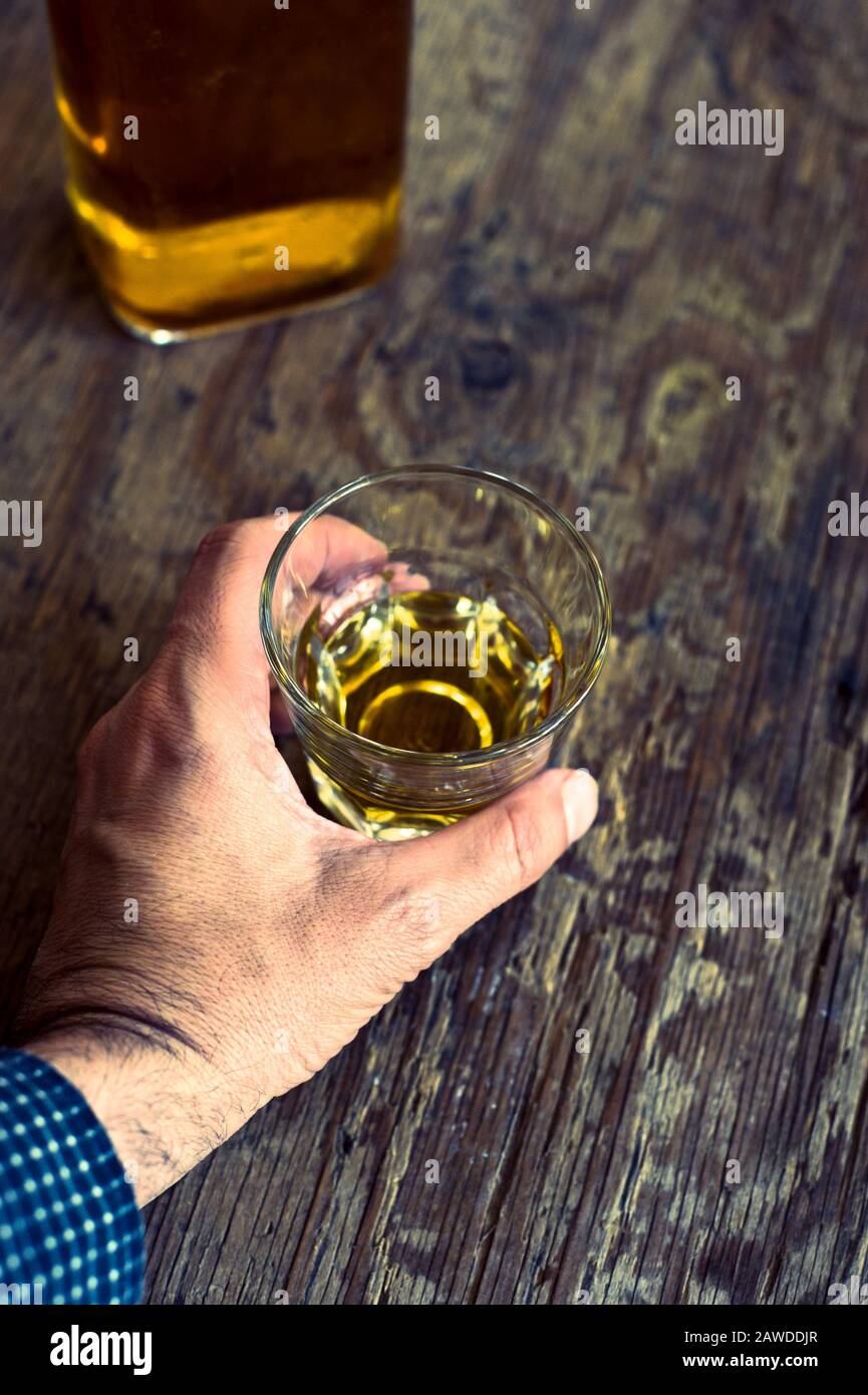 l'uomo che tiene un bicchiere di whisky, concetto di alcolismo Foto Stock