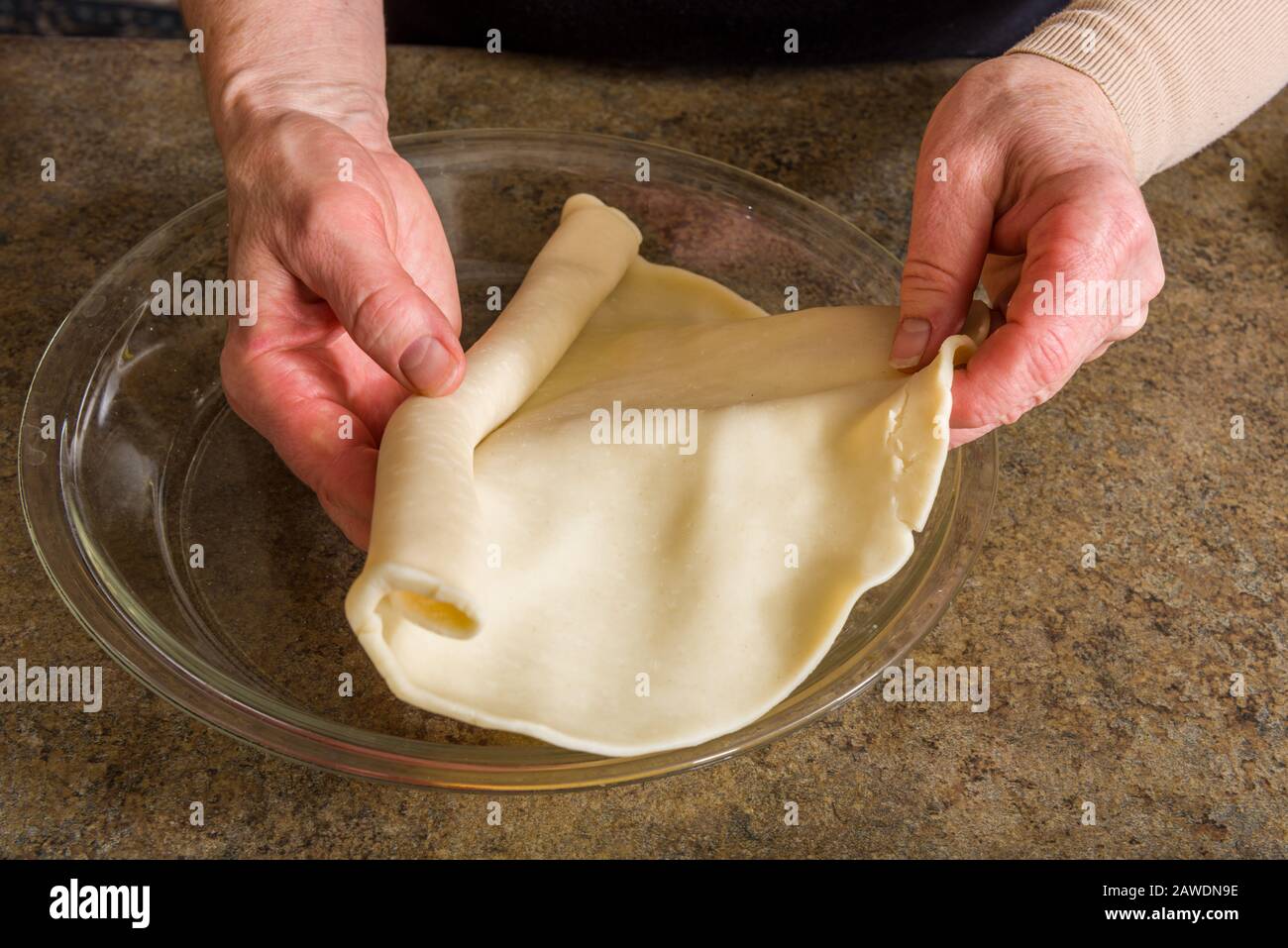 Crosta di torta che è tirata a parte e messa in una ciotola di vetro Foto Stock