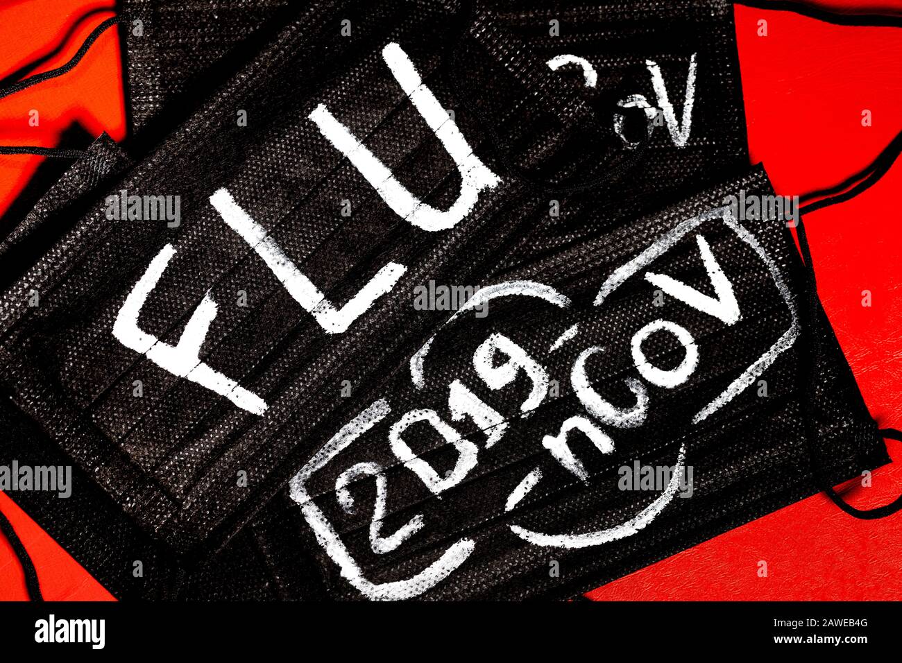 Maschere mediche nere con l'iscrizione 'FLU' e '2019-nCoV' su sfondo rosso Foto Stock