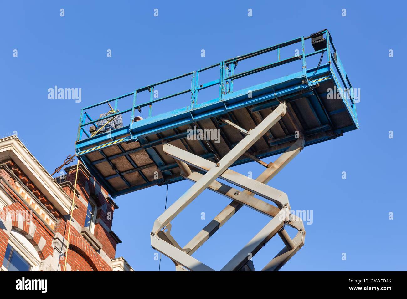 Piattaforma di lavoro con costruttori che riparano tetto storico olandese casa Foto Stock