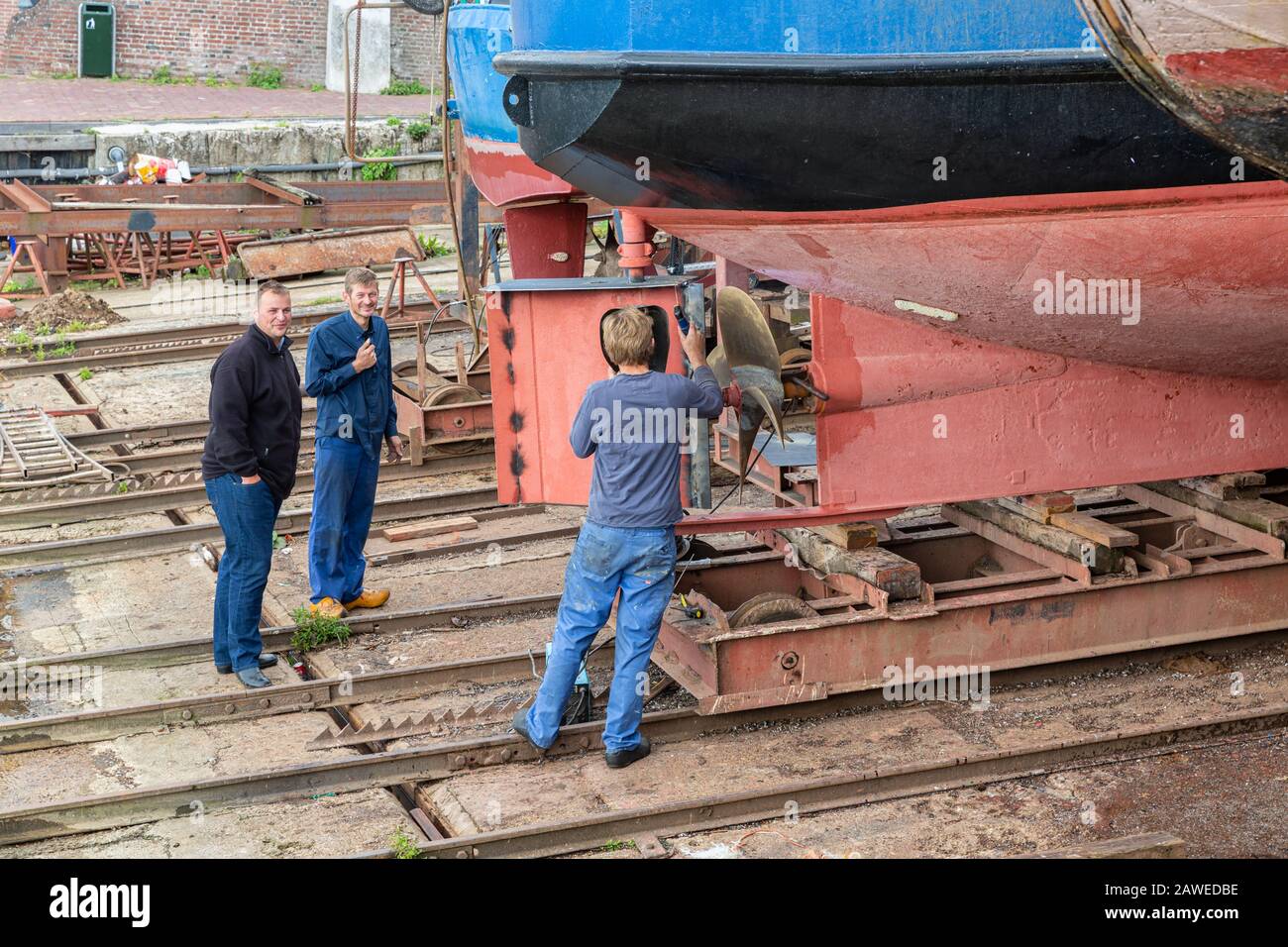 Lavoratori che riparano la nave timone presso il cantiere navale di Urk, villaggio olandese Foto Stock