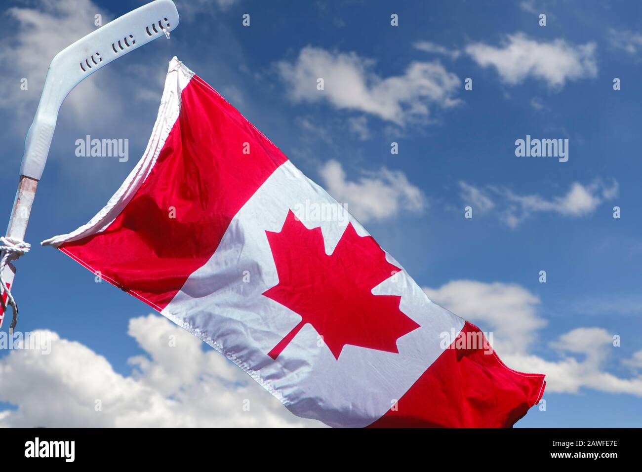 Bandiera canadese attaccata ad un bastone di hockey ondeggiare il Canada Day Foto Stock