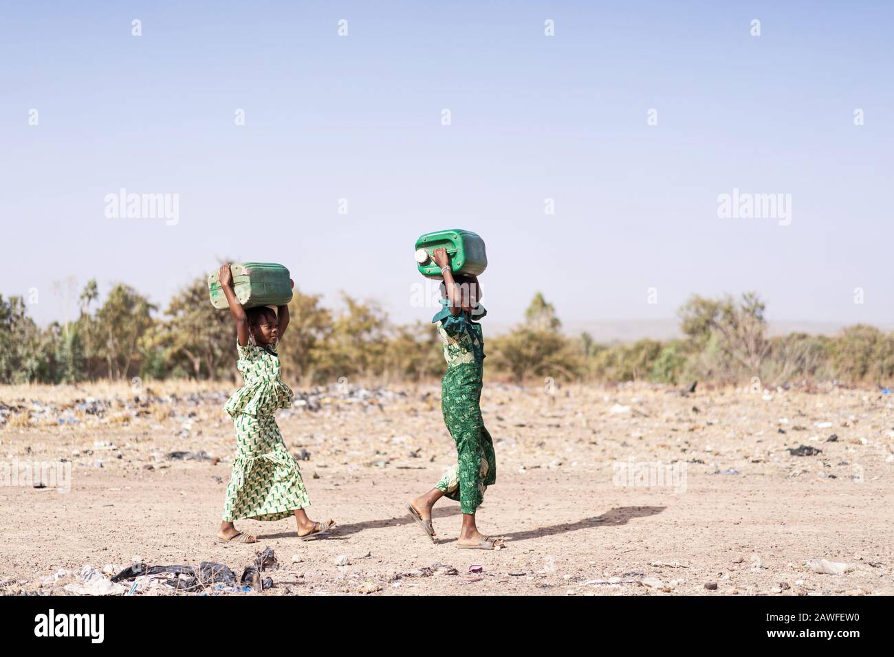 Gioiosa etnia africana Juvenile Raccogliere Acqua Pulita in un villaggio tipico Foto Stock