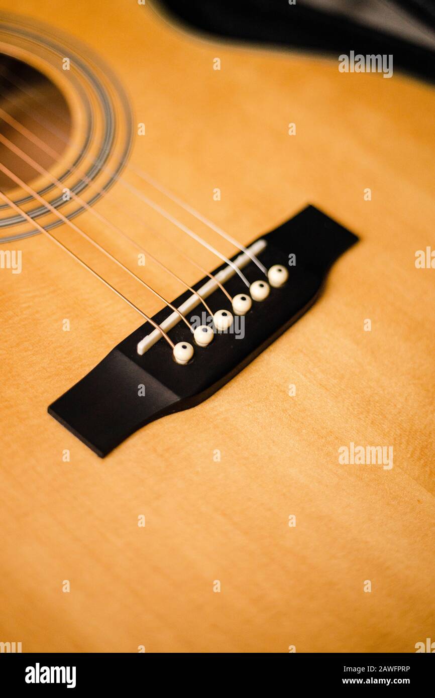 Ponte di chitarra acustica in legno con archi da vicino Foto Stock