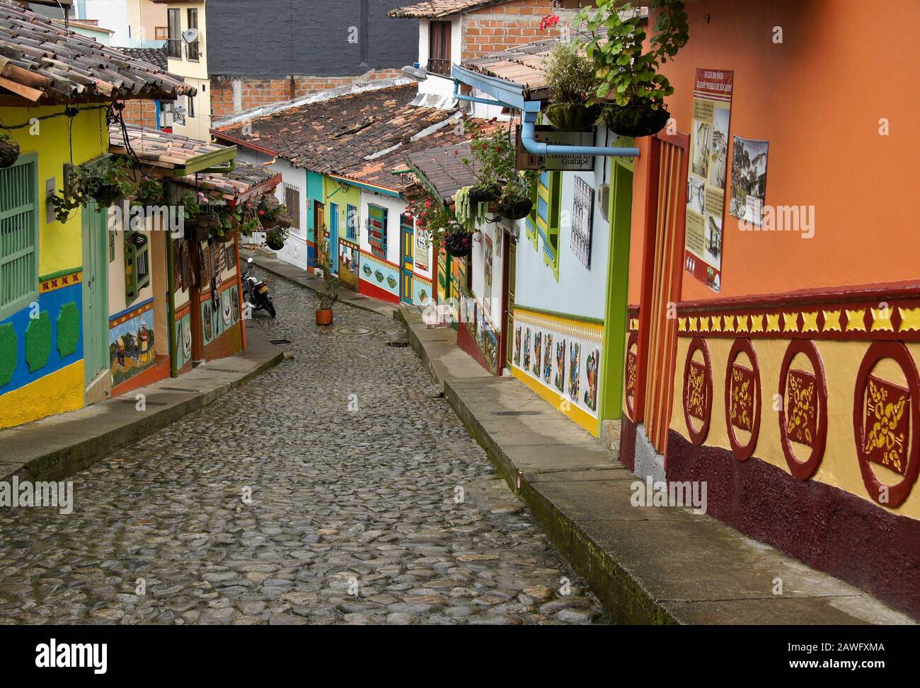 Colorati edifici con tetto piastrellato decorati con zocalos (fregi) linea Calle del Recuerdos, una strada pedonale acciottolata a Guatape, Colombia Foto Stock