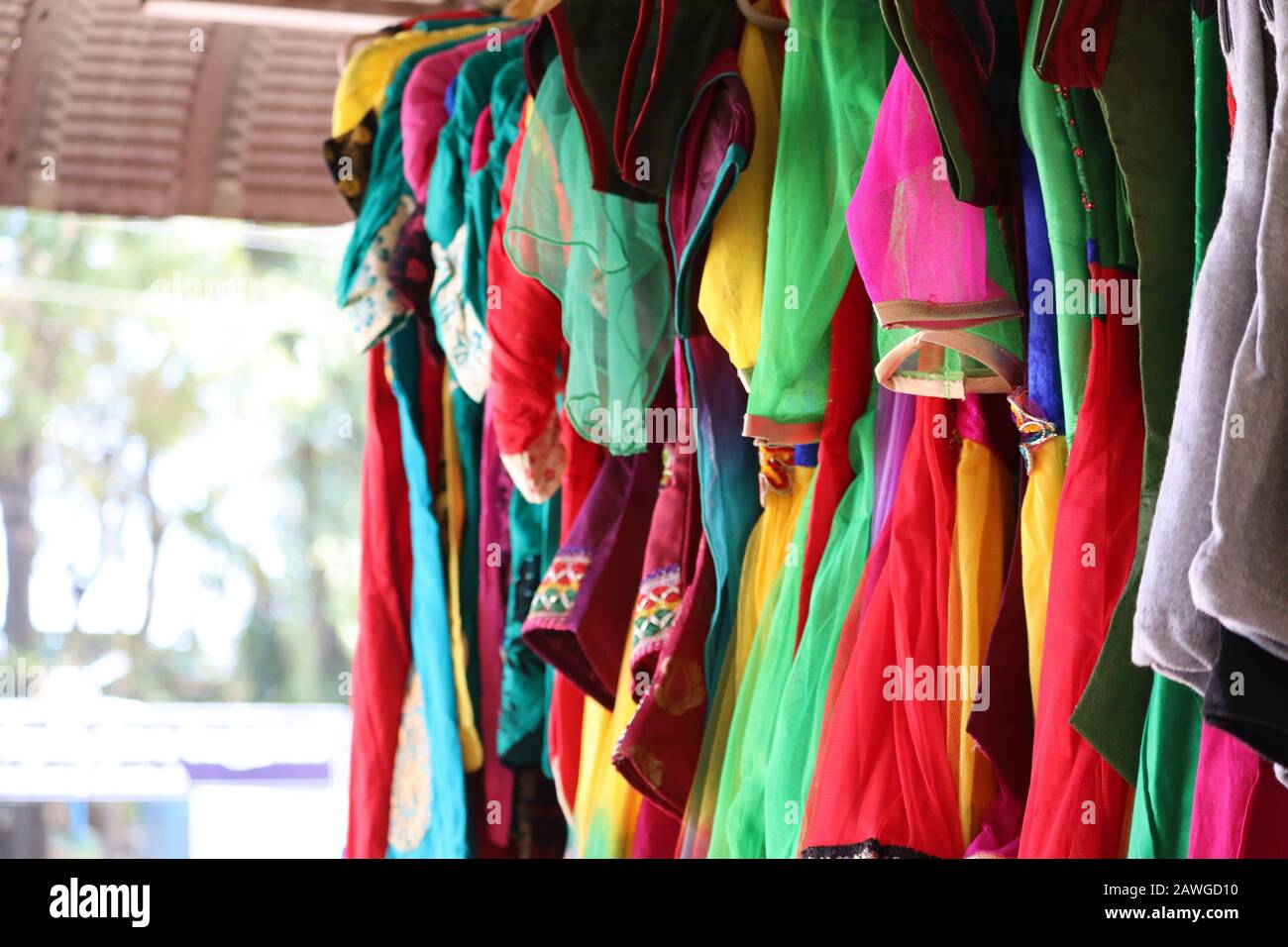 primo piano di stoffa verde, stoffa rossa, stoffa viola, stoffa blu, stoffa rosa appesa sulla verga nel mercato dei panni della strada in chchennai, mercato della strada Foto Stock