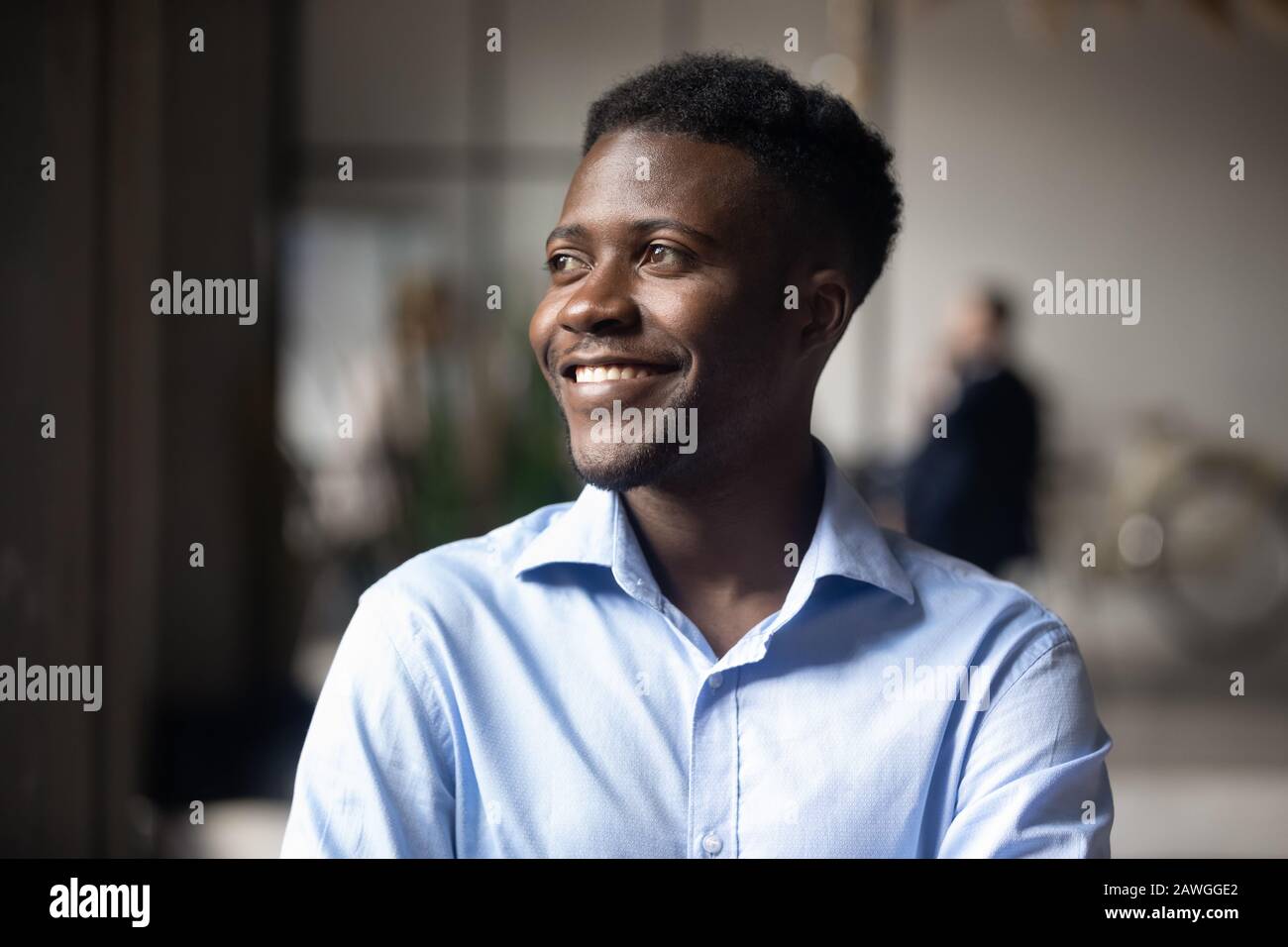 Un uomo d'affari di etnia Africana felice che si trova nell'area di lavoro moderna si sente soddisfatto Foto Stock