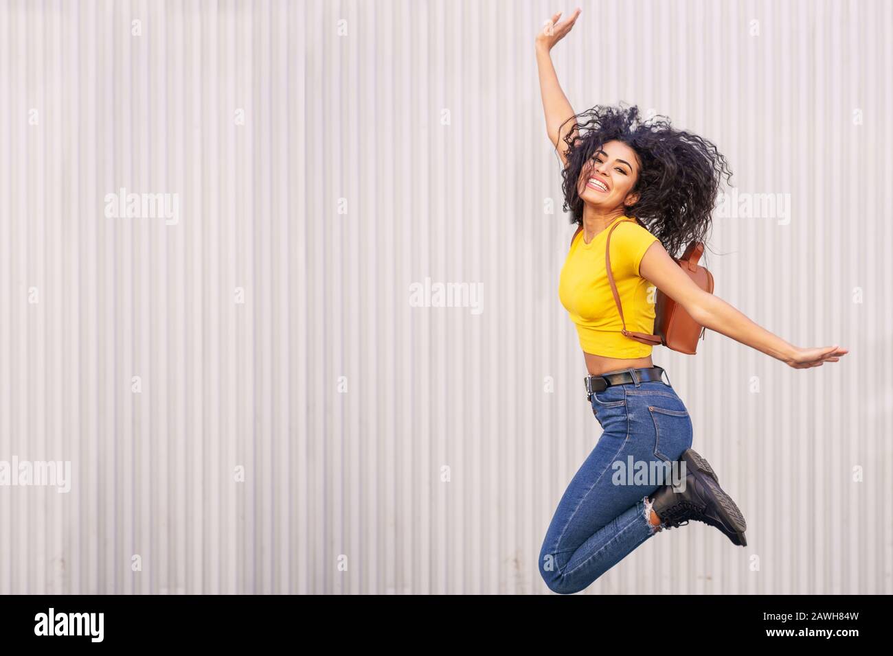 Felice donna araba salto in background urbano. Foto Stock