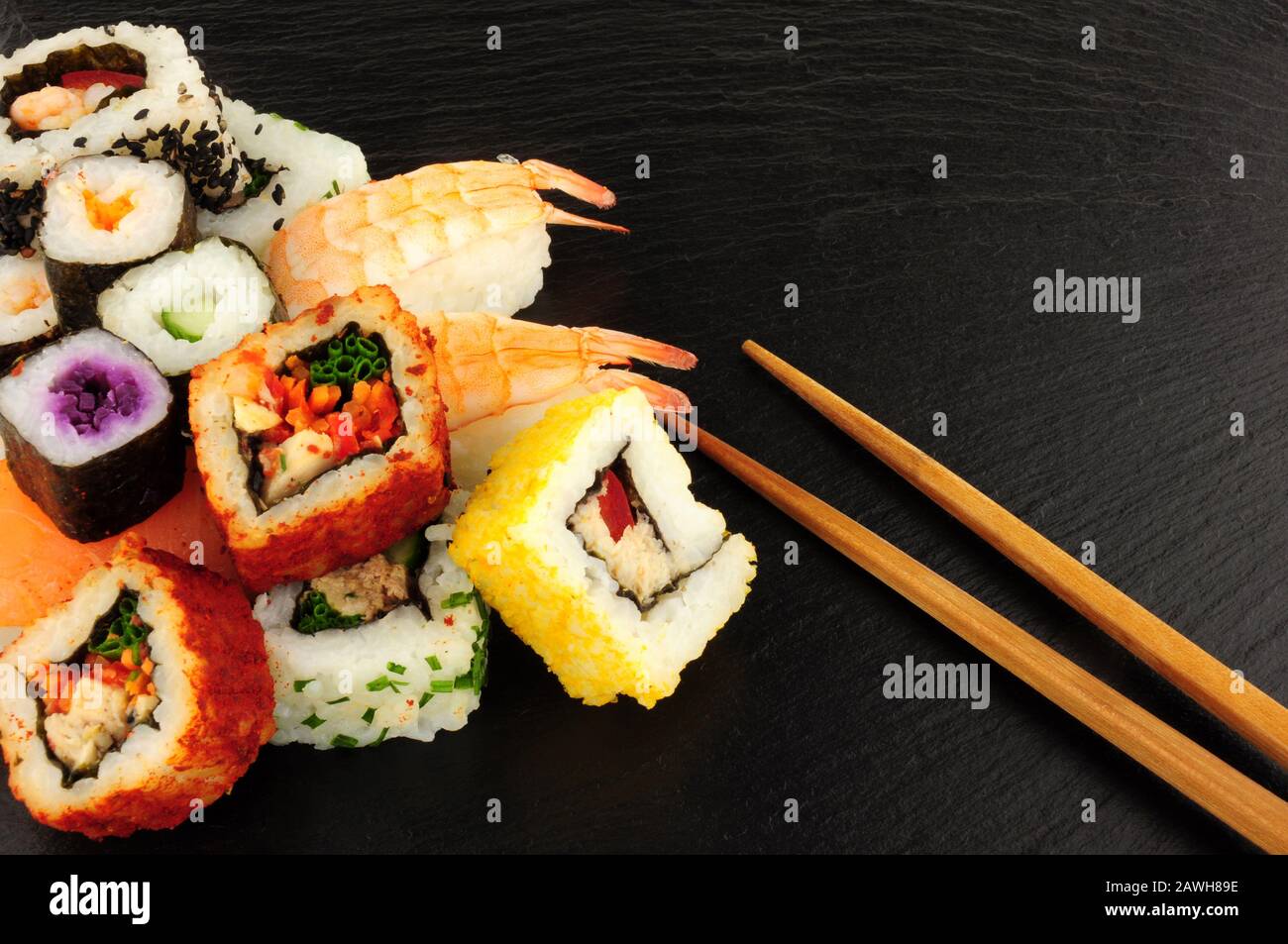 Panini freschi misti di sushi su uno sfondo di pietra di ardesia Foto Stock