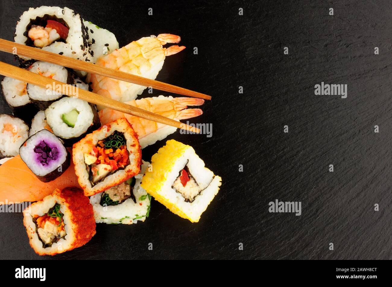 Panini freschi misti di sushi su uno sfondo di pietra di ardesia Foto Stock