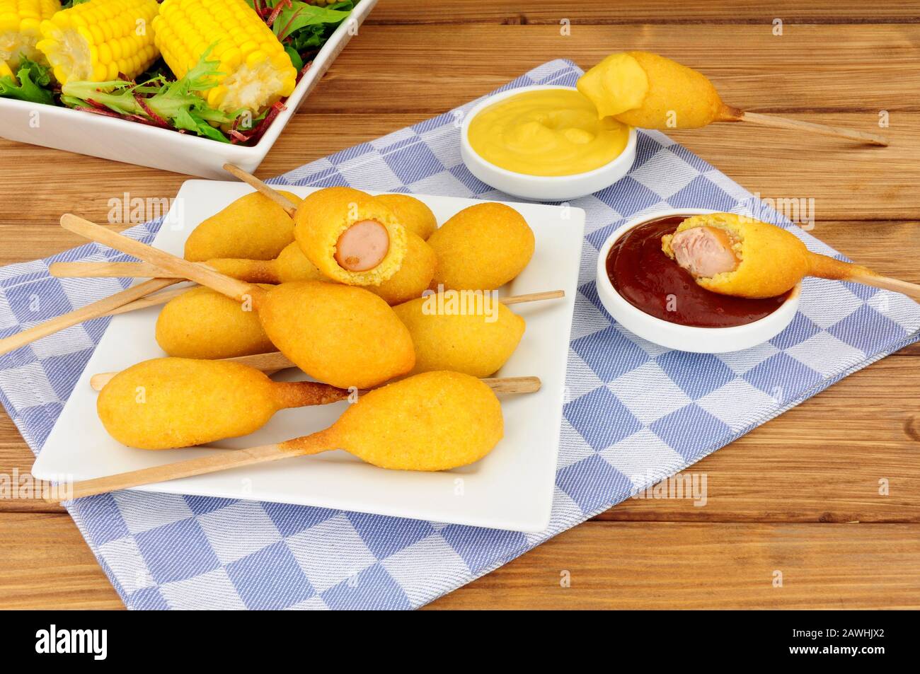 Mini party corndogs su bastoncini di legno con senape e salse di pomodoro Foto Stock