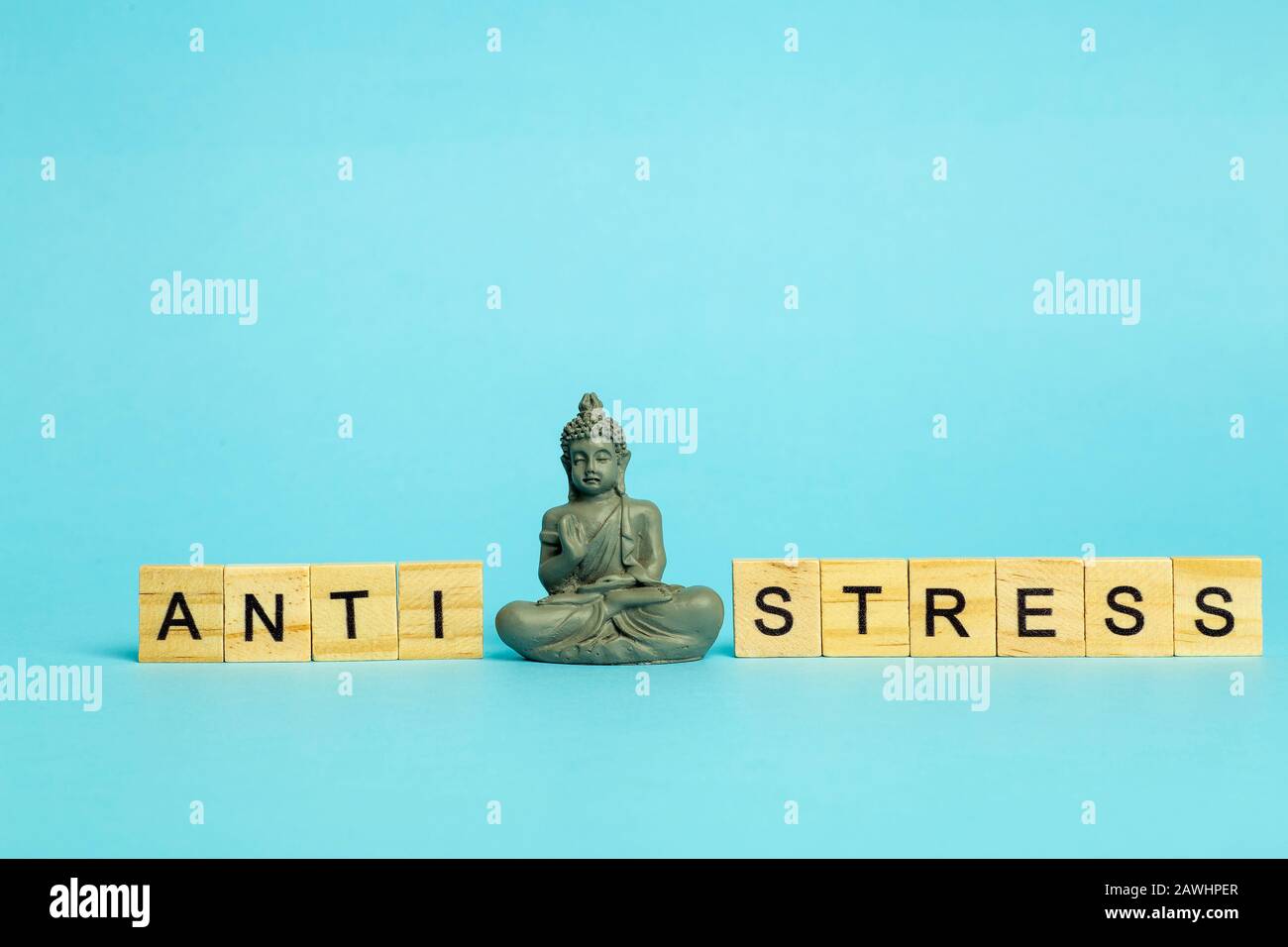 Concetto anti-stress. L'iscrizione Anti stress su sfondo blu puro con una figura meditante. Riduzione dello stress e controllo. Foto Stock